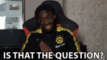 a man wearing a bvb jersey sits in a chair with the question is that the question