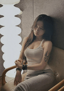 a woman with a tattoo on her arm is sitting on a couch