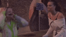 a man and two women are fighting on a sidewalk .