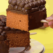a piece of cake is being taken out of a chocolate cake
