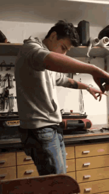 a man is working in a workshop with a stanley toolbox in the background