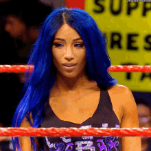 a woman with blue hair is standing in a ring with a sign that says supply