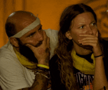 a man with a bandage on his head sits next to a woman who is wearing a shirt that says icon