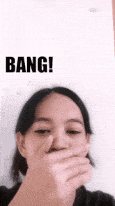 a woman covering her mouth with her hand and bang written on the bottom