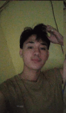 a young man taking a selfie with a cigarette in his mouth