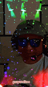 a man wearing headphones and sunglasses is surrounded by glowing lights and says guayanditoo