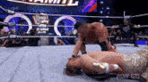 two men are wrestling in a ring with a sign that says double wing