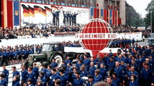 a large group of people are marching in front of a sign that says " er vereinigt euc "