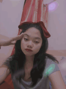 a girl wearing a red bow on her head