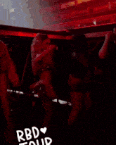 a group of people are gathered in a dark room with the words rbd tour written on the bottom