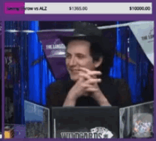 a man in a cowboy hat sits in front of a screen that says ' throw vs alz ' on it