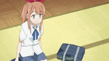 a girl with a red bow on her head is sitting on the floor next to a briefcase