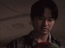 a man is holding a stuffed animal in his hands and looking at it