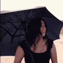 a woman holding an umbrella with a tree design on it