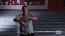 a man is running in front of a sign that says athletics on it