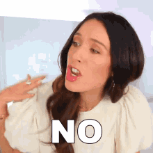 a woman in a white shirt is making a funny face and says no