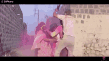 a group of people are standing next to each other in front of a wall .