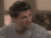 a close up of a man 's face in a grey sweater