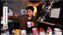 a man in a brown jacket is holding a cup in front of a piano and a microphone ..