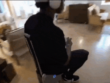 a man wearing headphones is sitting in a chair in a living room