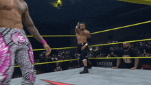a wrestling ring with a sign that says anthem in the background
