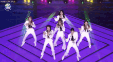 a group of women are dancing on a stage with a honeycam .org logo in the corner