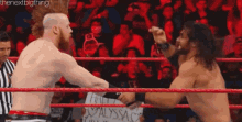 two men are fighting in a wrestling ring with a referee watching .