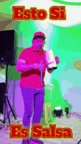 a man in a red shirt is holding a drum and the words " esto si es salsa " are on the bottom