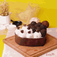 a heart shaped cake is on a wooden cutting board with easy pl written on it