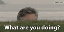 a man is peeking out of the grass and says `` what are you doing '' .