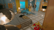 a man and woman are walking through a living room with a couch and ottoman