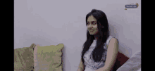a woman is sitting on a couch in front of a wall that says mocha city on it