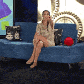a woman sitting on a blue couch with a totoro pillow