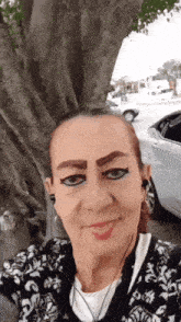 a woman taking a selfie in front of a tree