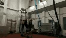 a group of people are doing a trick on a rope in a gym .
