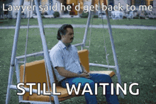 a man is sitting on a swing in a park waiting for a lawyer to get back to him .