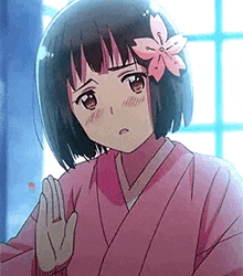 a girl in a pink kimono with a flower in her hair .