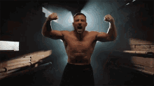 a man without a shirt is flexing his muscles