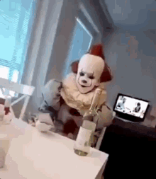 a clown is sitting at a table with a bottle of wine in his hand .