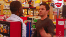 two men are standing next to each other in a store .