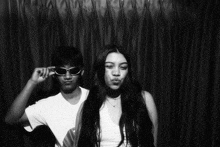 a man and a woman wearing sunglasses pose for a picture