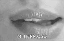 a black and white photo of a woman 's lips with the words `` mi hermoso '' written in white letters .