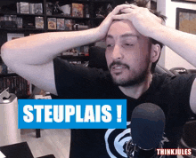 a man holds his head in front of a sign that says steuplais !