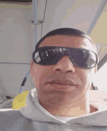 a man wearing sunglasses looks at the camera with his mouth open