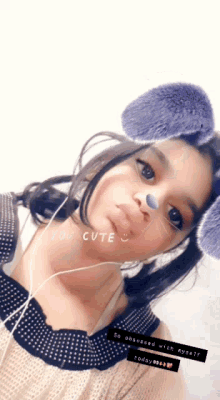 a girl wearing ear plugs and a mask that says you cute on it