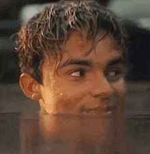 a close up of a young man 's face in a pool of water