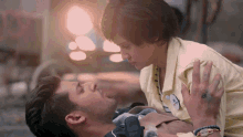 a man is laying on the ground while a woman looks on