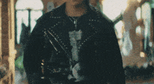 a man wearing a black leather jacket and a black t-shirt with a cat on it