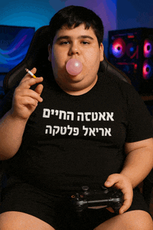 a boy blowing a bubble while holding a controller