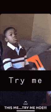a young boy is sitting on a couch holding a nerf gun and saying try me .